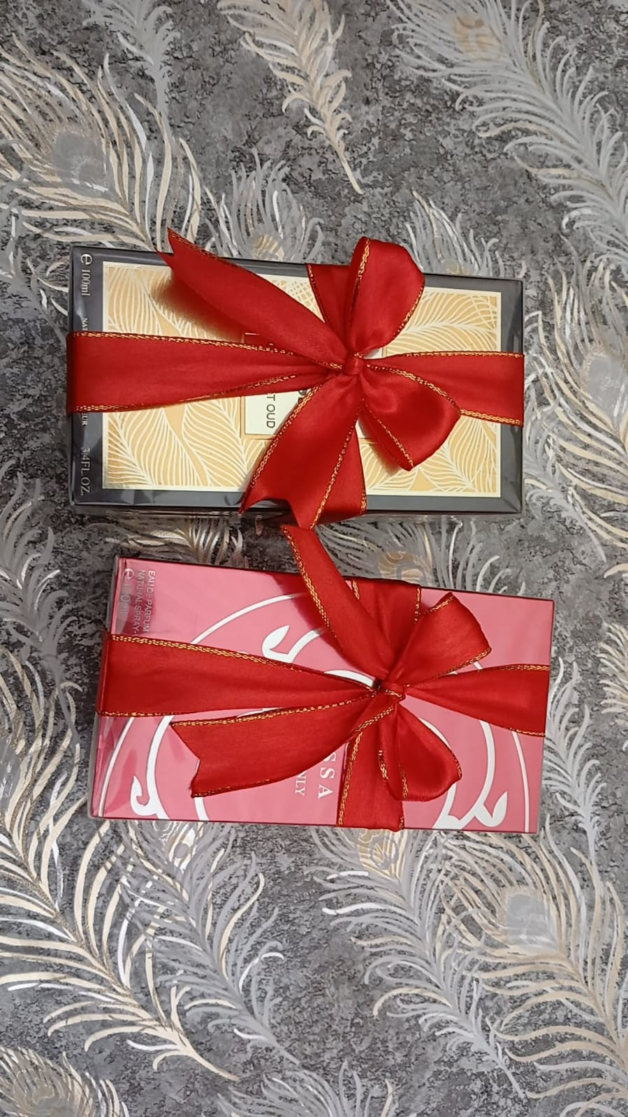 Wrapped perfume and beauty gifts with red ribbons